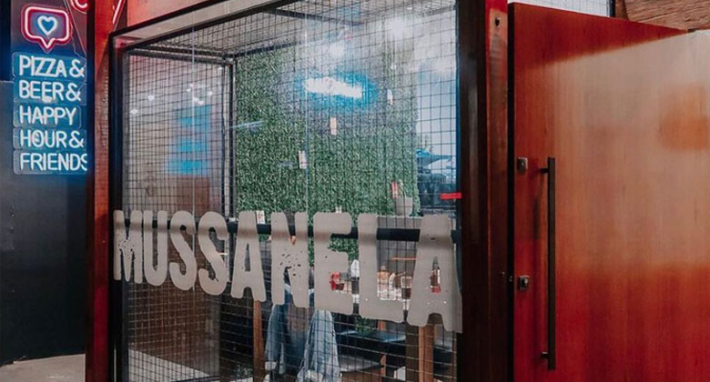Fachada da Pizzaria Mussanela, no Cambuci, com letreiro e vitrine